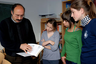 Dr. Ömer Lütfi Yavuz zeigt Marie, Nahid und Sara (v.l.) die Bibliothek des AKI (Foto: Ingrid Fisch)