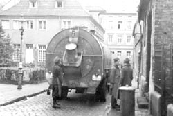 Kriegsgefangene hinter einem Müllwagen